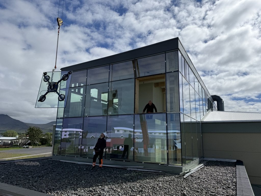 Glerrúða hífð með sogskálum við útskiptingu einangrunarglers í Grundaskóla á Akranesi